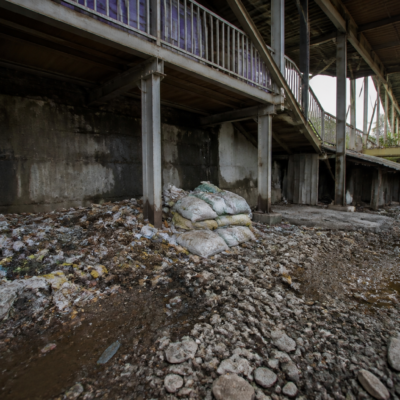 Waste and construction debris accumulated beneath a pedestrian bridge at Dombivli railway station