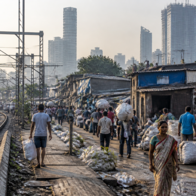 Dharavi redevelopment area in Mumbai with dense residential structures and railway infrastructure nearby