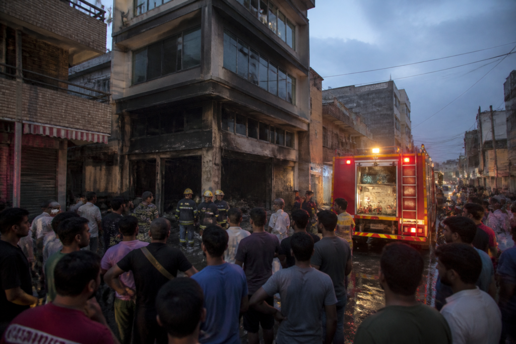 Delhi restaurant fire response near Jafrabad with people gathered outside a low-rise building