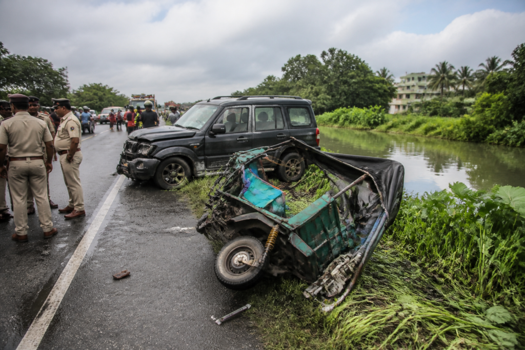 Emergency response at a Basanti Highway crash site beside a roadside waterbody