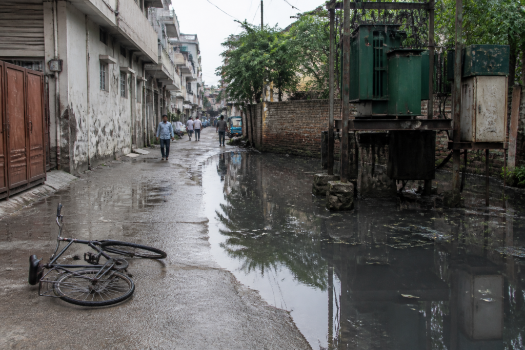 Faridabad sewer water pooled beside a roadside transformer on a congested urban road