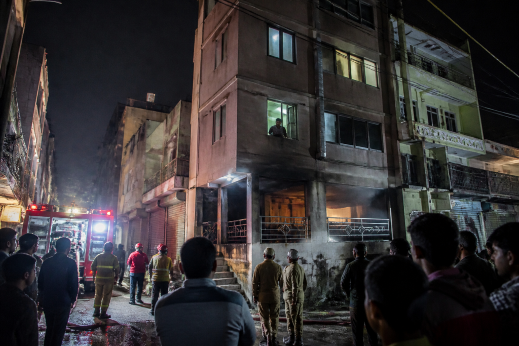 Delhi restaurant fire response near Maujpur as people escape a first-floor window