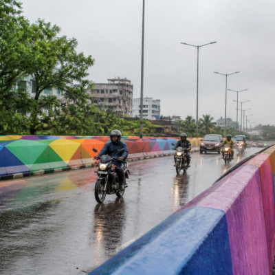 Kolkata rainbow flyover with wet road surface and passing motorcycles