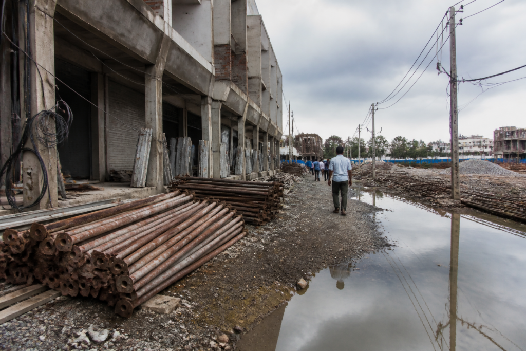 Ahmedabad construction site with exposed wiring and workers near building materials