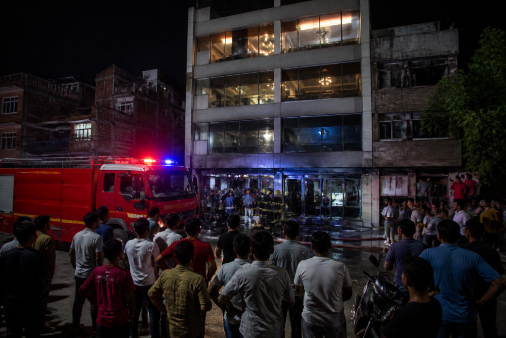 Delhi restaurant fire response outside a multi-storey building in Maujpur