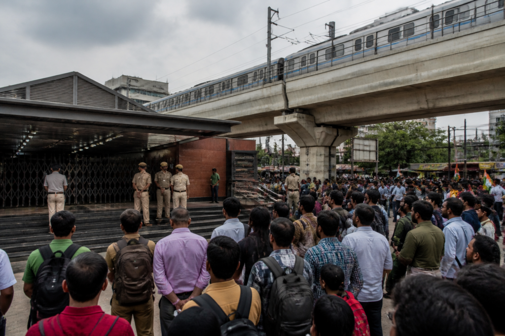 Delhi Metro station closures during a protest, with commuters outside a Delhi station