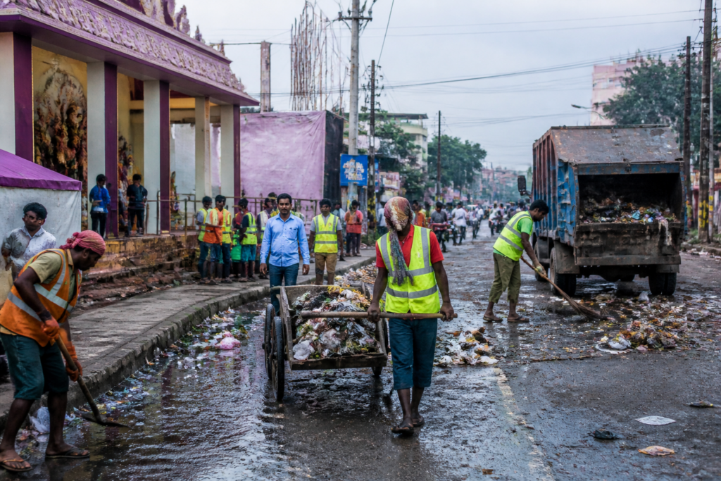 Dhanbad sanitation workers cleaning a city road during the Durga Puja season