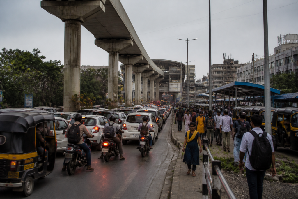 Pimpri-Chinchwad Metro traffic moving around elevated metro pillars and a congested station approach