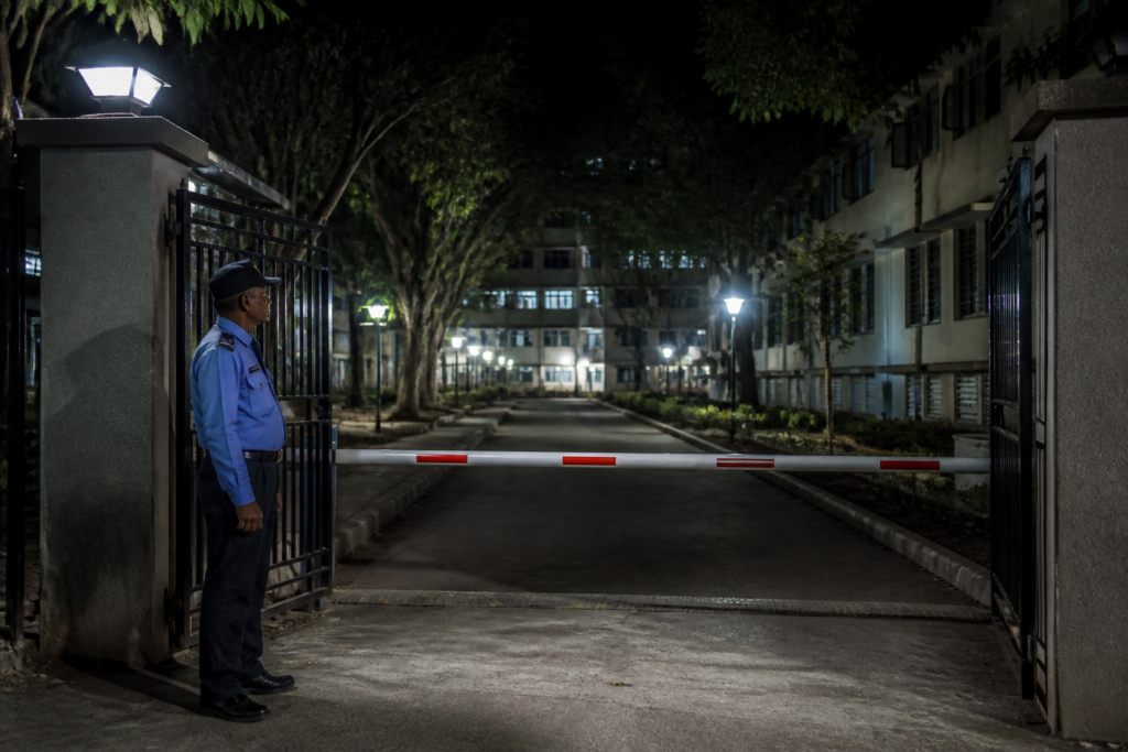 Pune University girls hostel building and its guarded entrance at night