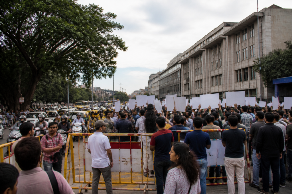 Bengaluru protest sites near a busy commercial road with police barriers and pedestrians
