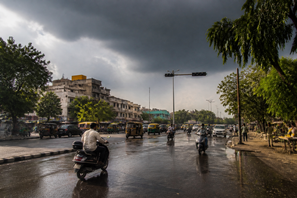 Gujarat rain forecast over a hot Ahmedabad street under darkening monsoon clouds