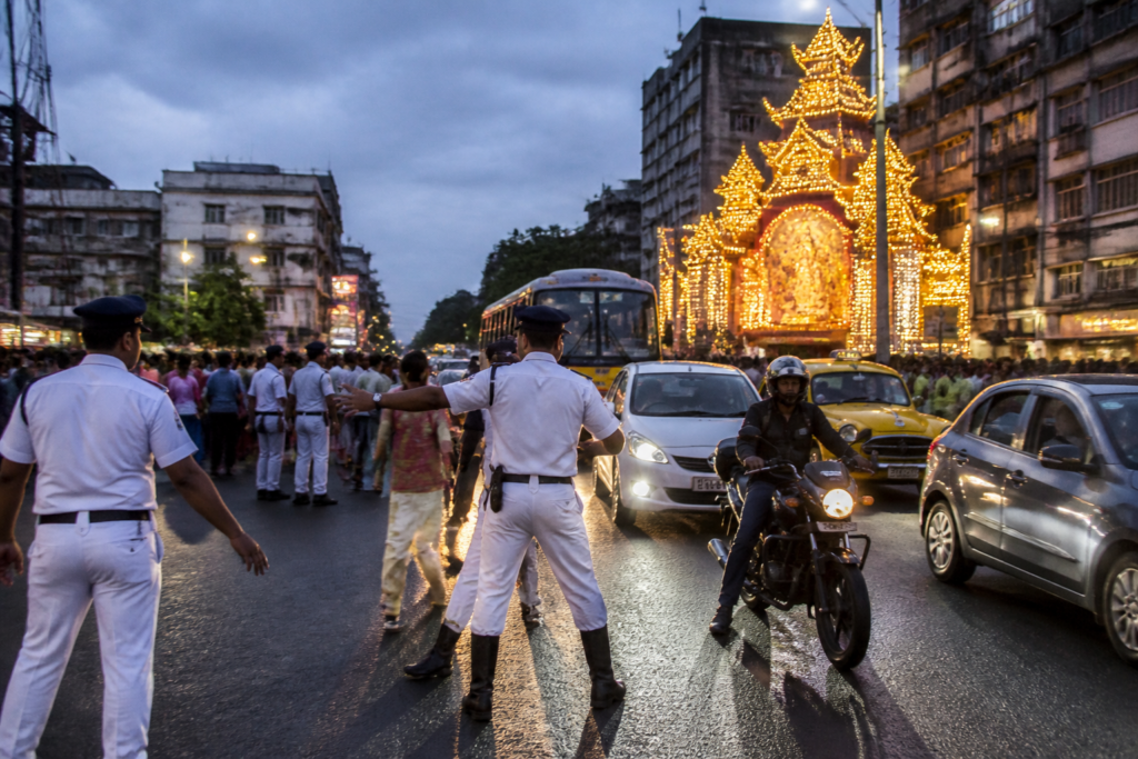 Kolkata Puja traffic managed by police and temporary personnel near crowded city roads