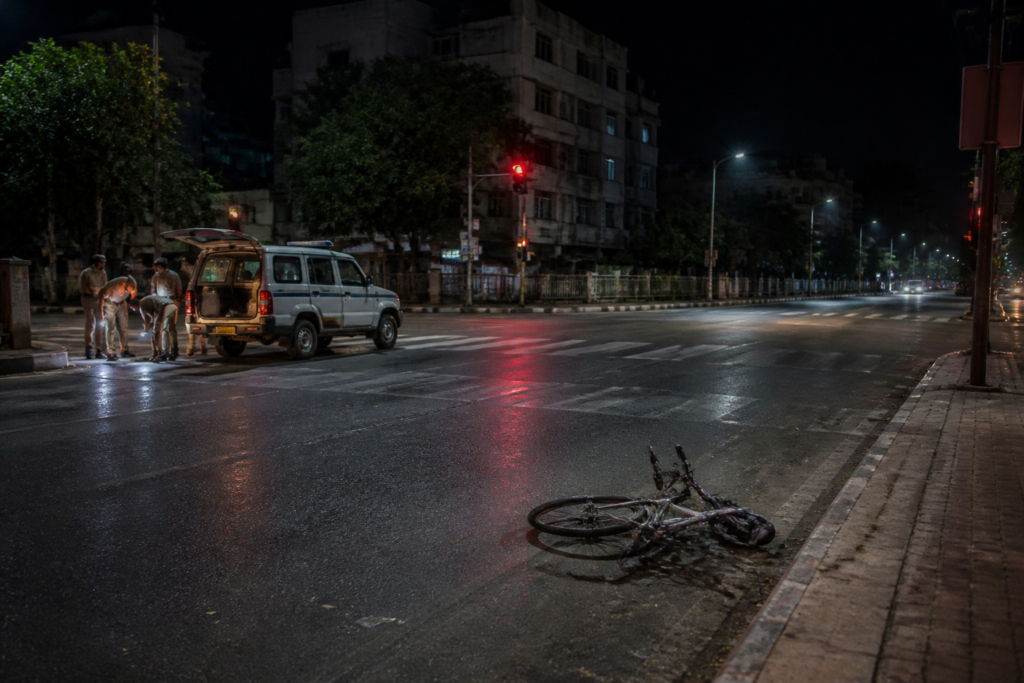Jaipur hit-and-run scene near a city intersection at night with a cyclist’s damaged bicycle