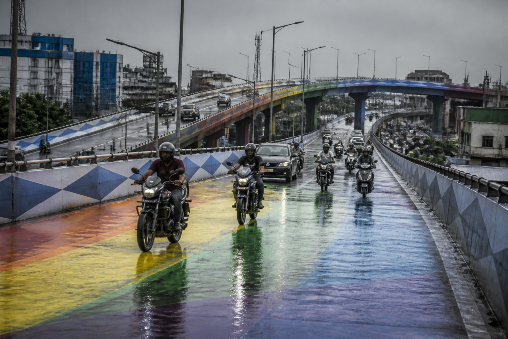 Kolkata flyover paint covering a wet Chingrighata road surface after drizzle