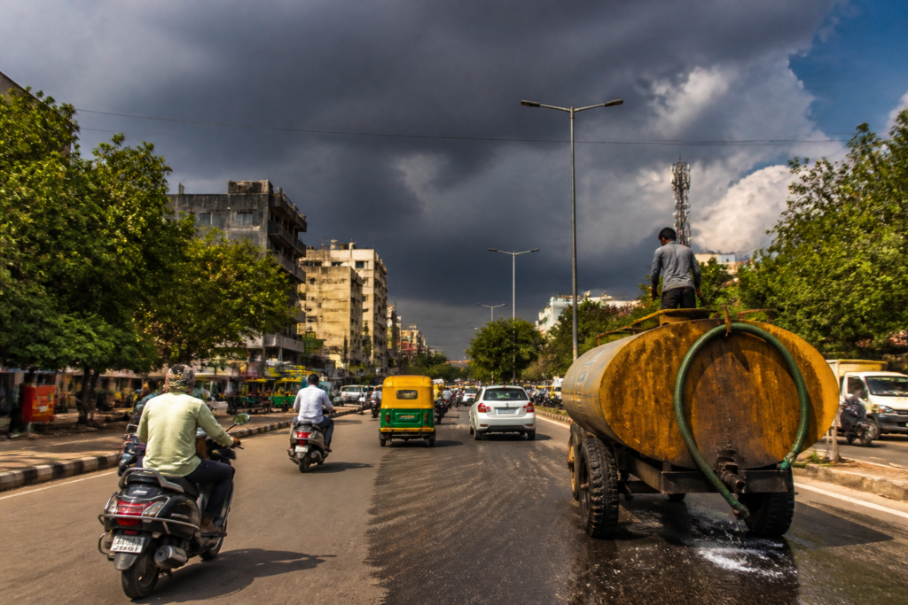 Gujarat weather forecast showing rain clouds over a hot Ahmedabad urban landscape