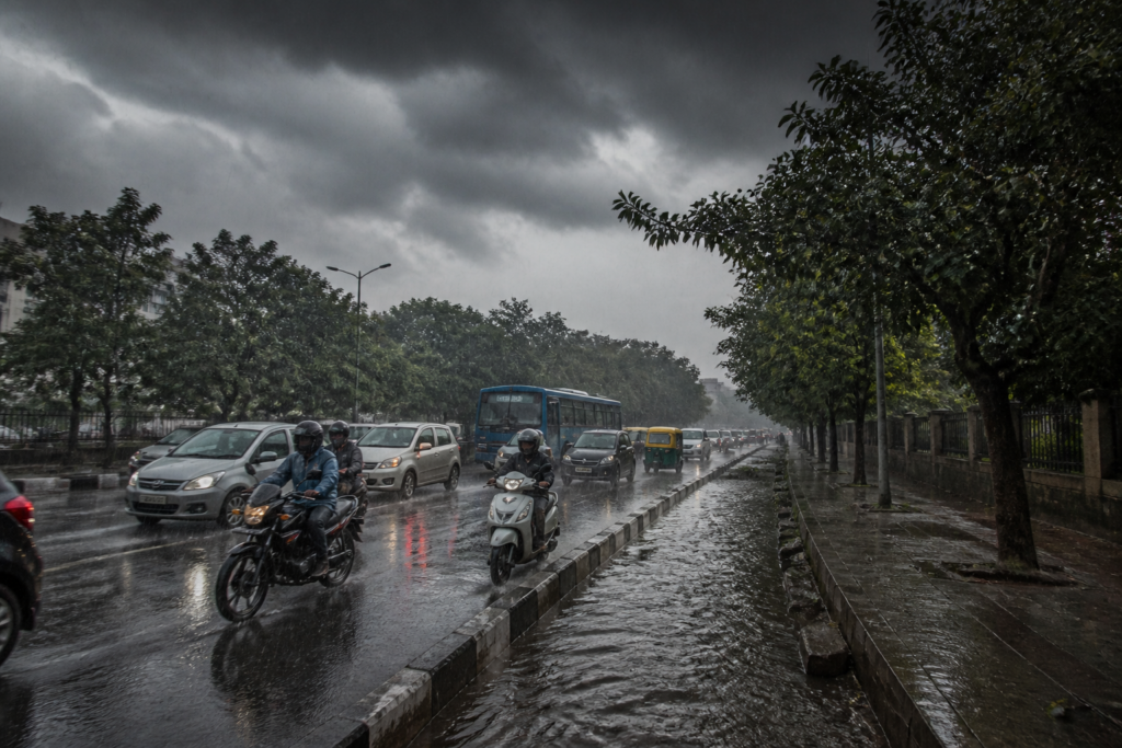 Karnataka rains over a city road with dark monsoon clouds and wet traffic conditions