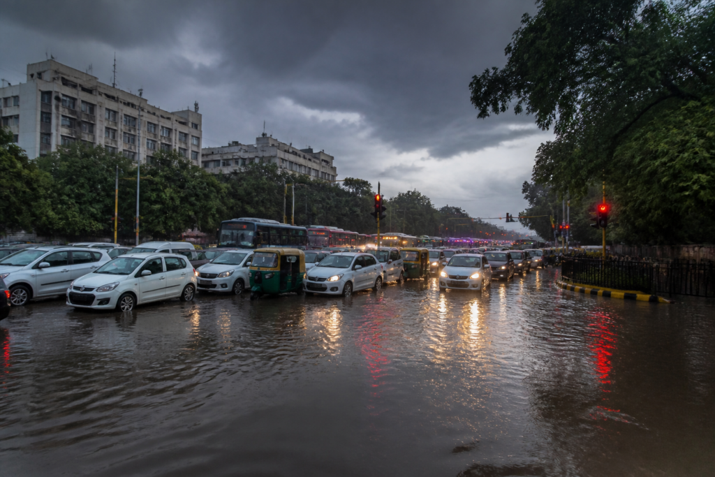 Delhi traffic stalled by heavy rain and waterlogging near a congested urban junction