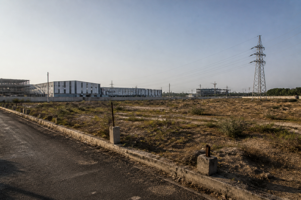 Sanand GIDC hotel project site with an industrial plot and utility corridor area