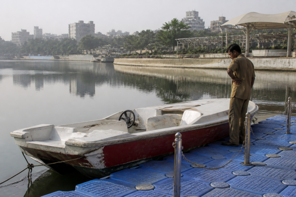 Ahmedabad boating operators beside parked boats at Kankaria Lake after a prolonged service suspension