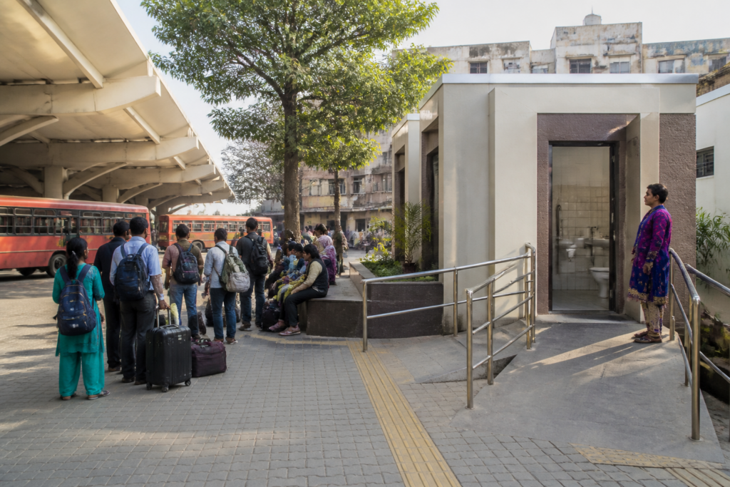 Transgender toilets planned at a Maharashtra ST bus stand with passenger facilities and buses in the background.