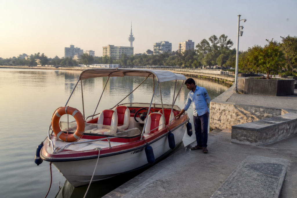 Ahmedabad boating operator beside a parked boat at Kankaria Lake