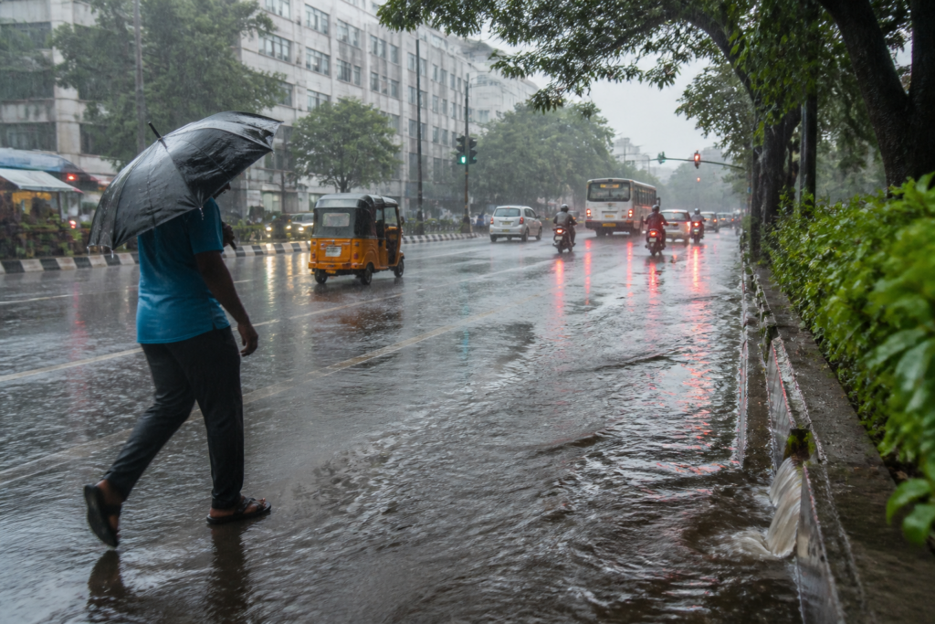 Tamil Nadu northeast monsoon rain over a Chennai street with wet roads and dark storm clouds