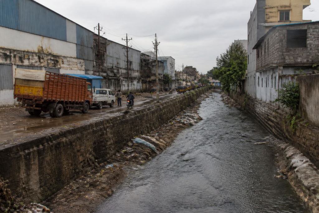 Kukatpally nala near Hyderabad industrial areas, showing a narrowed stormwater drain and surrounding encroachments