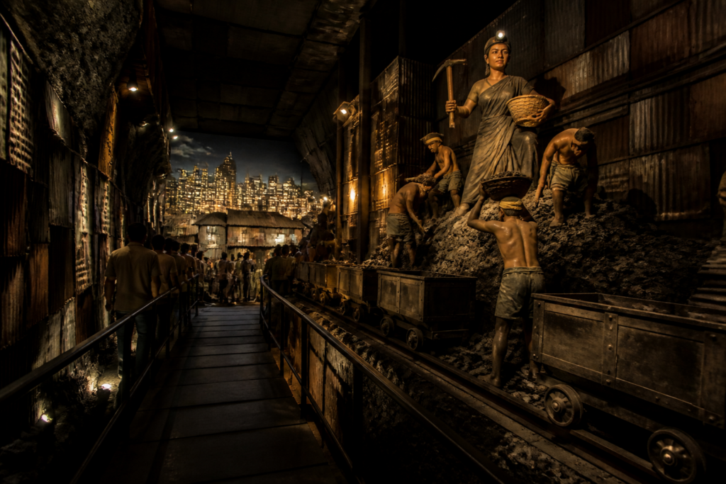 Raniganj coal mining-themed Durga Puja pandal showing miners, coal and a city skyline