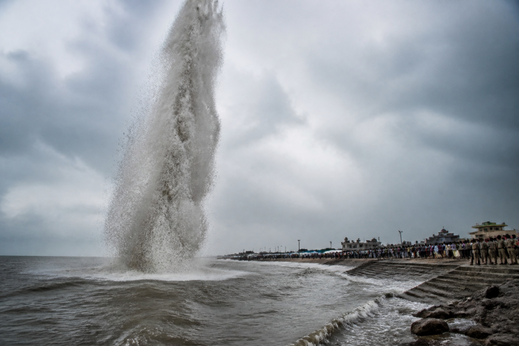 Gangasagar water spout rising from the sea near a crowded bathing ghat