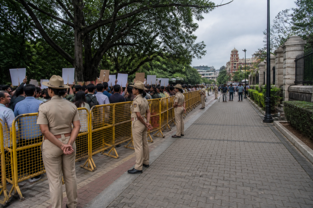 Bengaluru protest restrictions at Freedom Park, with barricades and demonstrators in an urban public space
