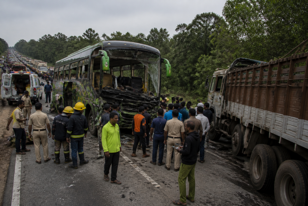 Piriyapatna bus crash site with a damaged sleeper bus and lorry on BM Road