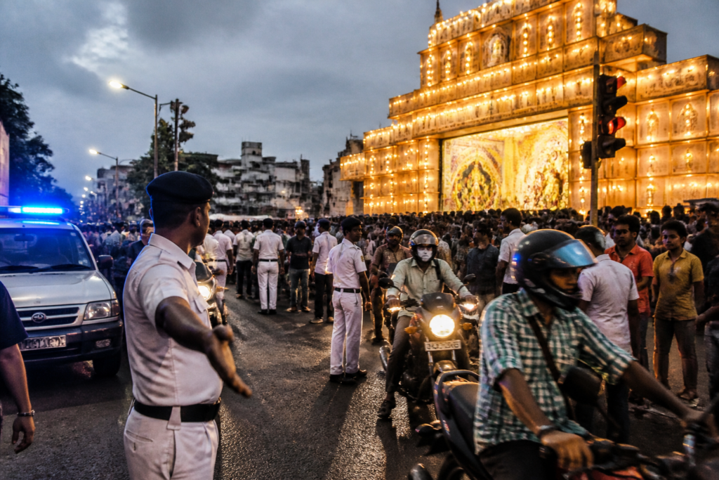 Kolkata Durga Puja security personnel managing crowds near a decorated pandal