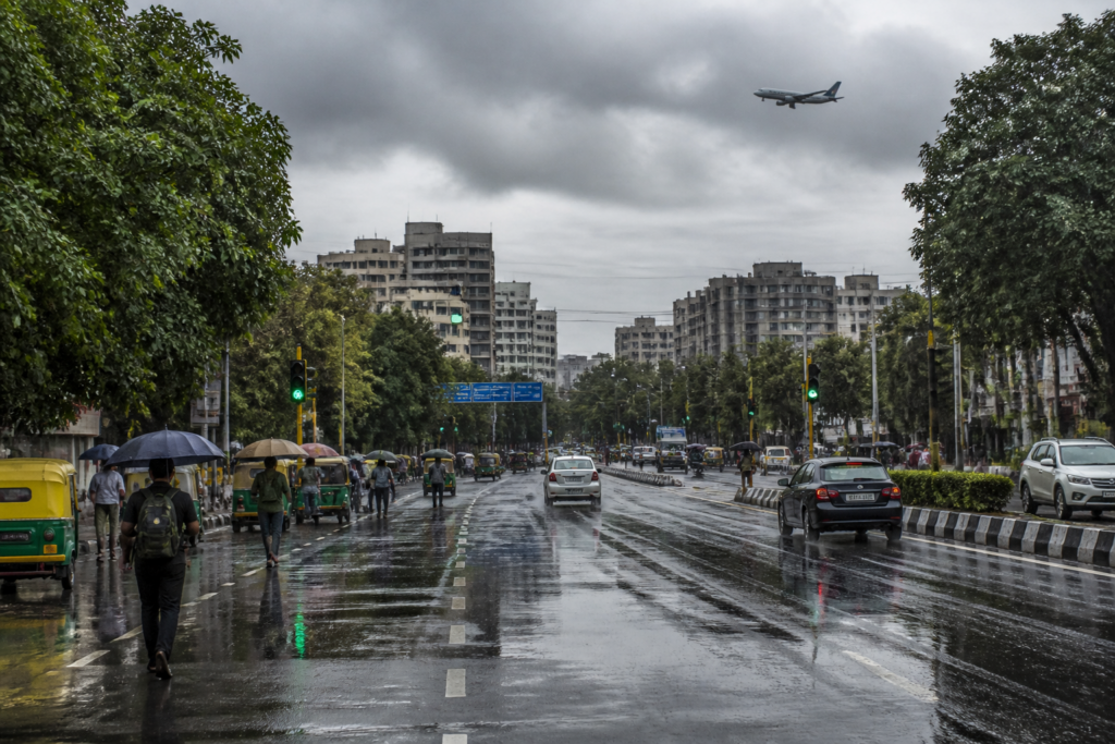 Delhi weather after rain, with cloudy skies over a wet urban road