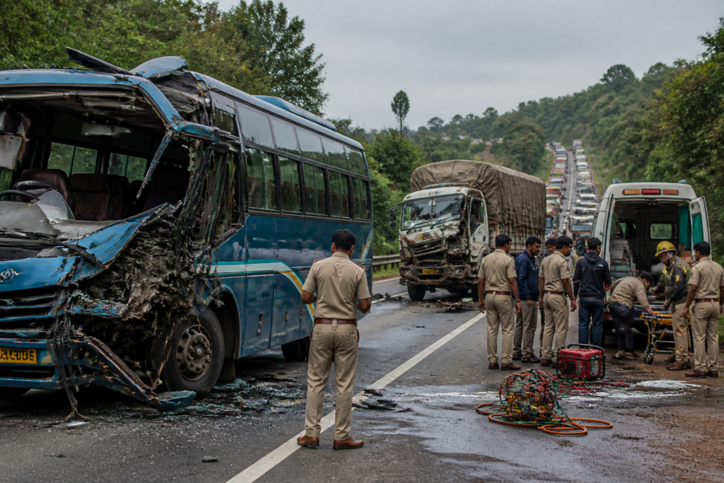 Mysuru bus accident scene involving a damaged sleeper bus and lorry on a highway