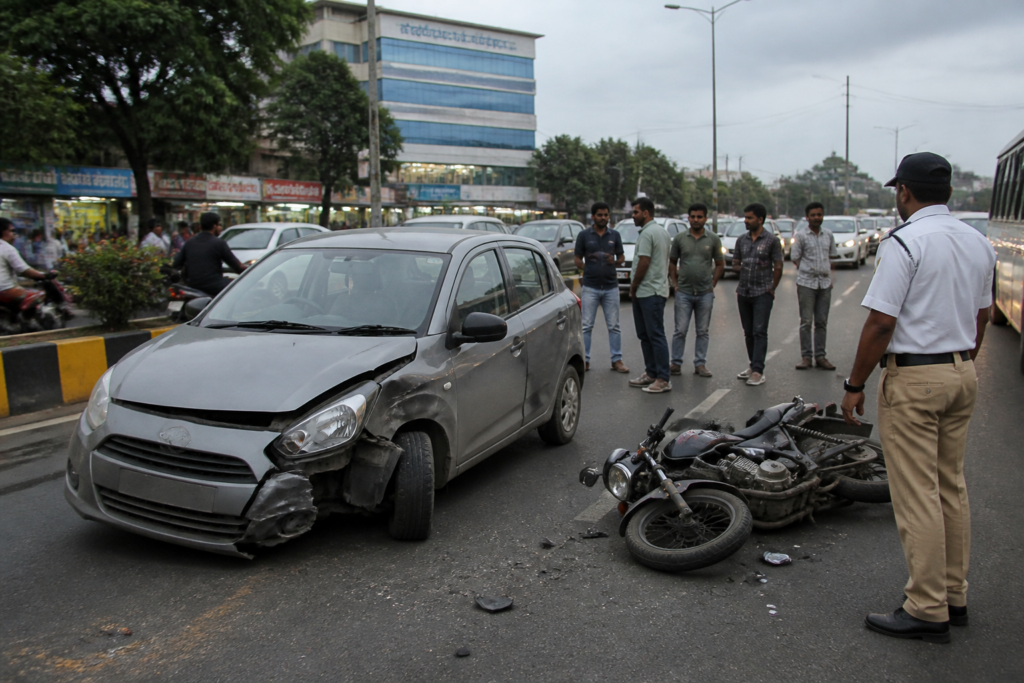 Kothrud road accident scene on Paud Road in Pune with a damaged car and gathered pedestrians