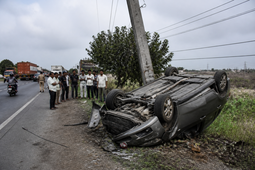Pune-Solapur Highway crash site near Uruli Kanchan with a damaged overturned car