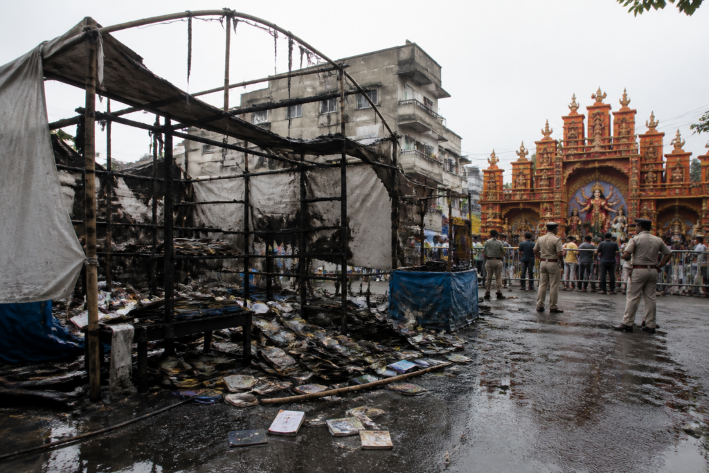 Damaged CPIM book stall near a Bengal Durga Puja venue after a reported fire