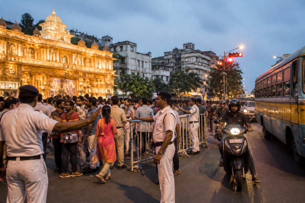 Kolkata Puja security personnel managing crowds and traffic near a Durga Puja pandal
