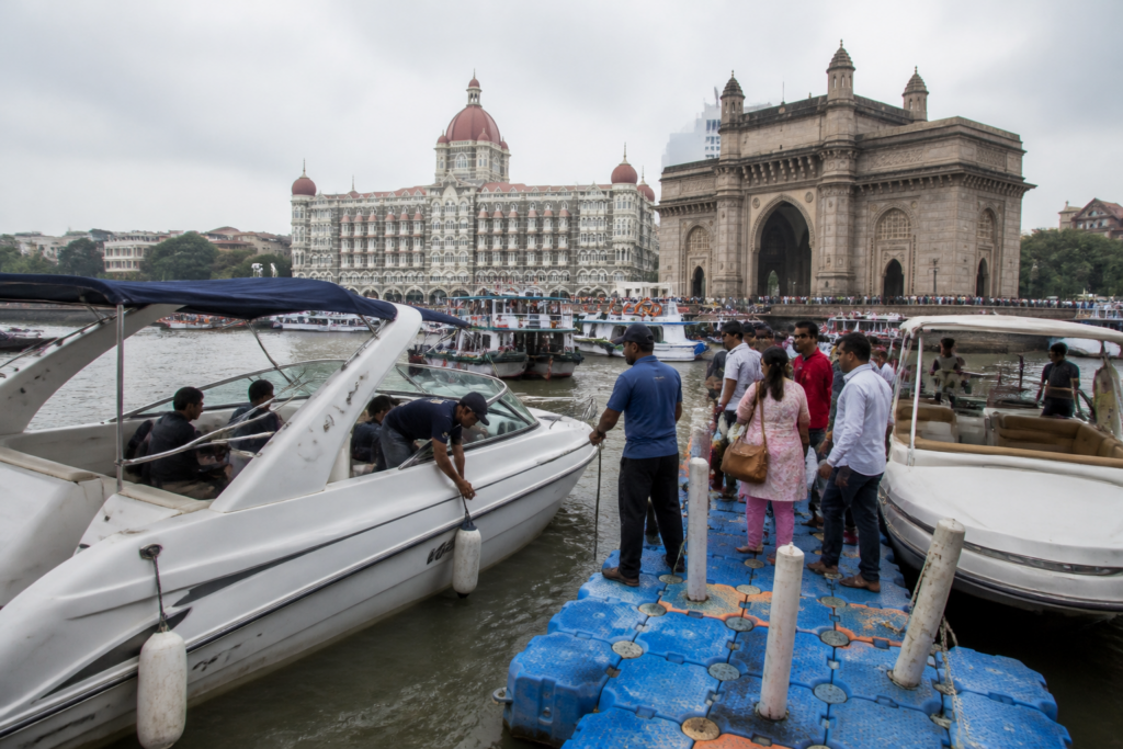 Gateway of India yacht rides beside a floating pontoon at Mumbai waterfront