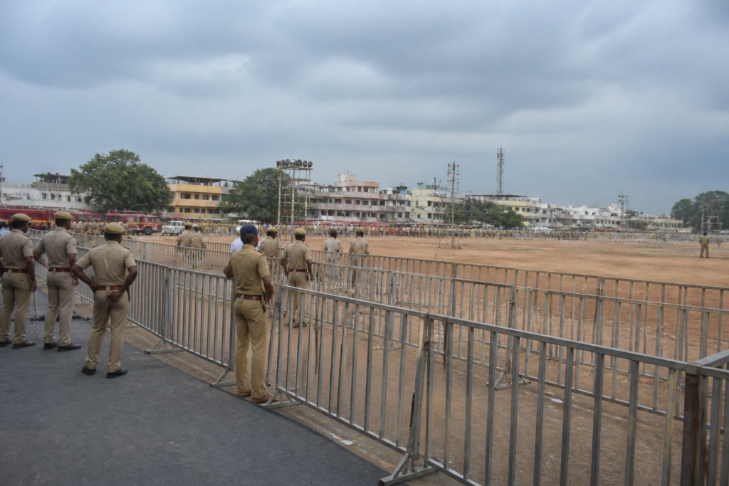 Karur stampede case site with crowd-control barriers and emergency vehicles in Tamil Nadu