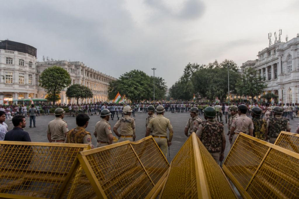 Delhi protest detentions near Connaught Place as police secure Central Park during a march.