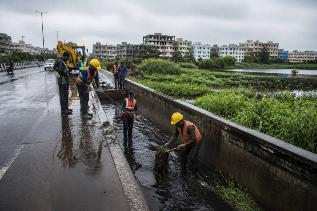 Chennai monsoon preparedness work near a storm water drain and flood-prone urban road
