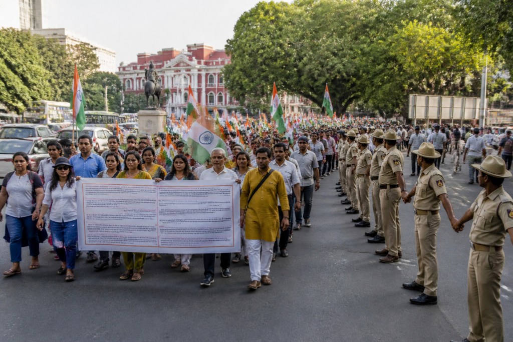 Tiranga March Bengaluru participants carrying national flags near a city landmark