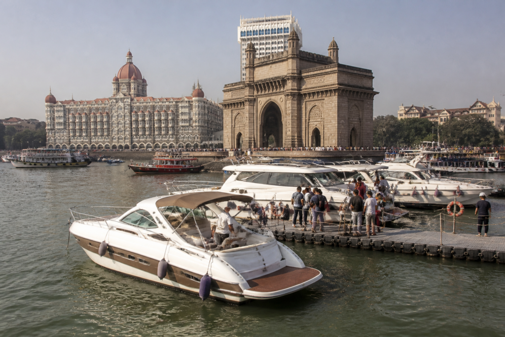 Gateway of India yacht rides near Mumbai’s waterfront with boats and the historic monument visible.