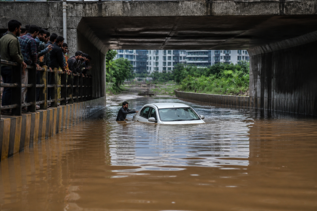 Waterlogged Panathur underbridge in Bengaluru with a partially submerged white sedan