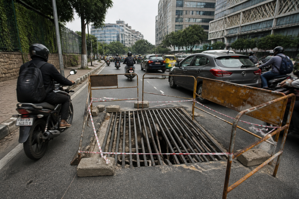 Broken road grating barricaded on Nrupathunga Road in Bengaluru
