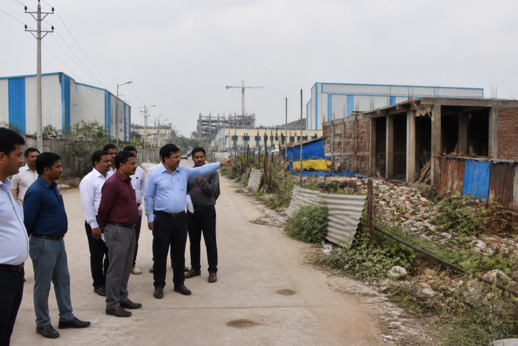 Greater Noida illegal construction site in an industrial area with unfinished structures and officials inspecting the premises