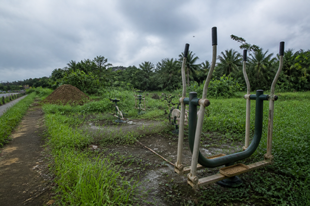 Overgrown Thuravumkara open gym beside deposited soil in Ernakulam