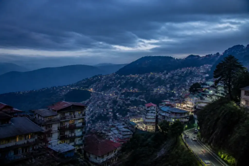 Shimla earthquake coverage showing hillside buildings under an early-morning sky