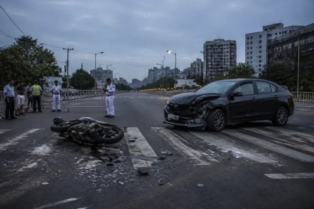 Kolkata road accident scene at the Urbana crossing with a motorcycle and damaged car